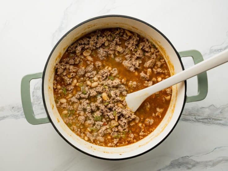 Simmering white bean turkey chili in a Dutch oven.