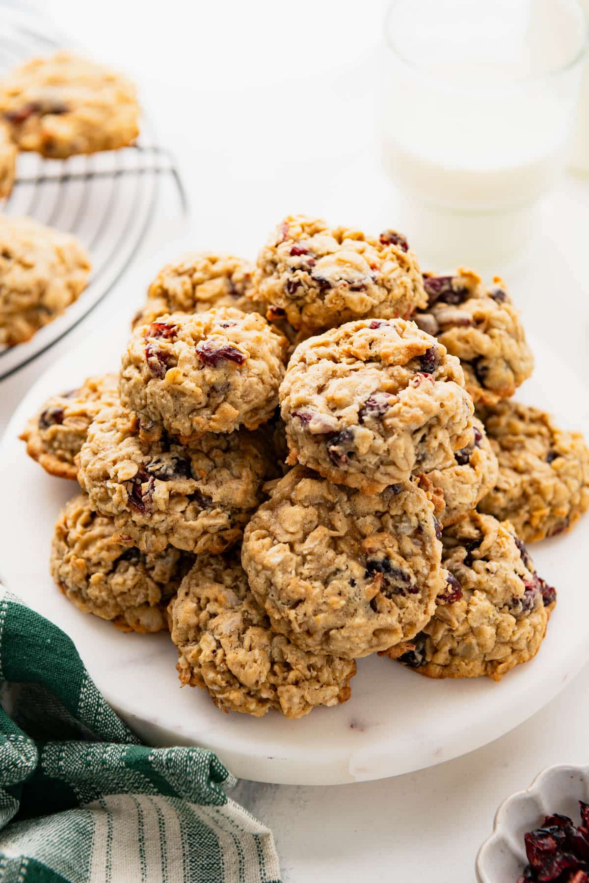 Stack of oatmeal cranberry cookies on a white serving tray.