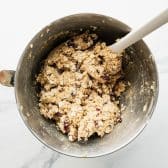 Stirring oats and cranberries into dough.