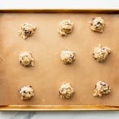 Dough balls on a parchment lined baking sheet.