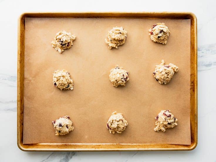 Dough balls on a parchment lined baking sheet.