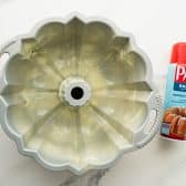 Greasing and flouring a bundt pan with nonstick baking spray.