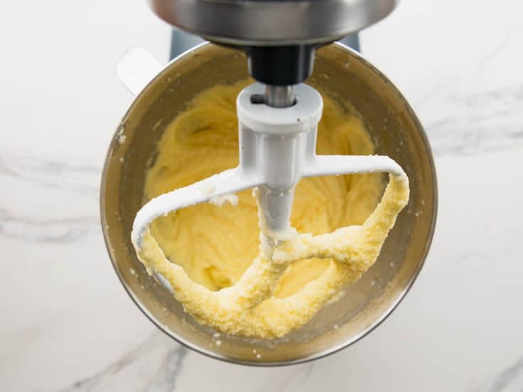 Mixing eggs into creamed butter and sugar.