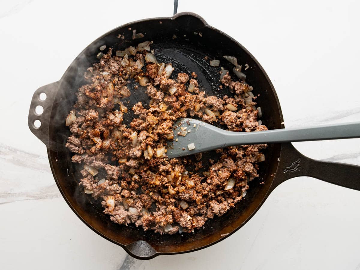Adding the seasoning to the meat mixture.