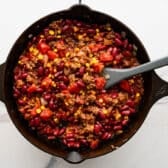 Ingredients for chili filling in a cast iron pan.