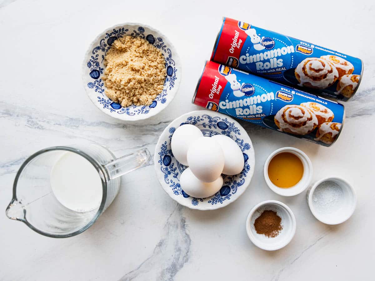 Ingredients for a Pillsbury cinnamon roll casserole on a white table.