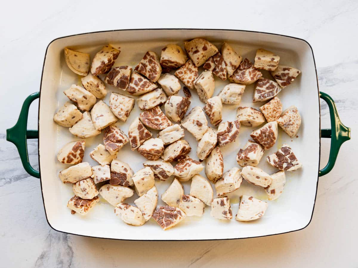 Cut cinnamon rolls in a baking dish.