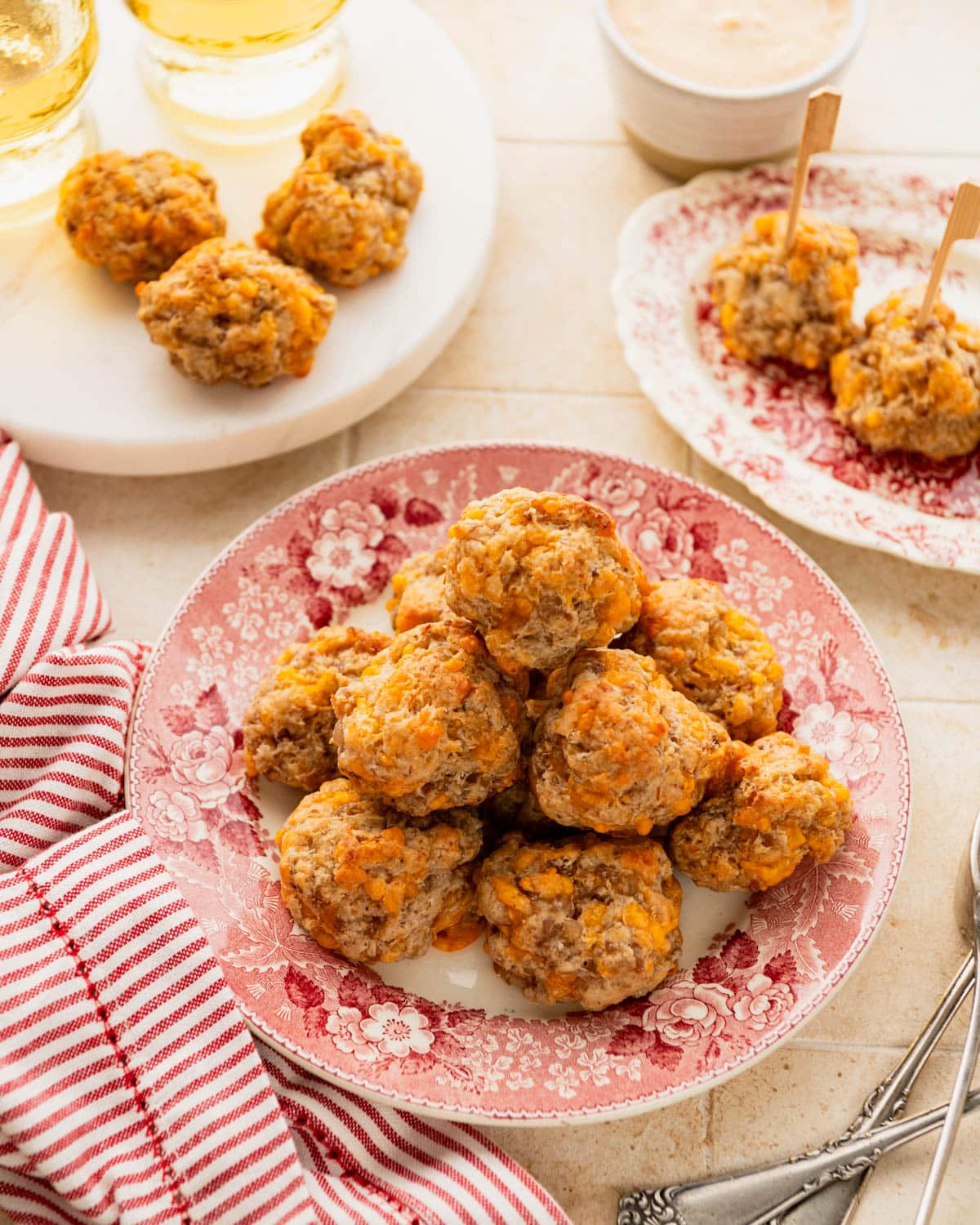 Table full of cream cheese sausage balls with cocktails.