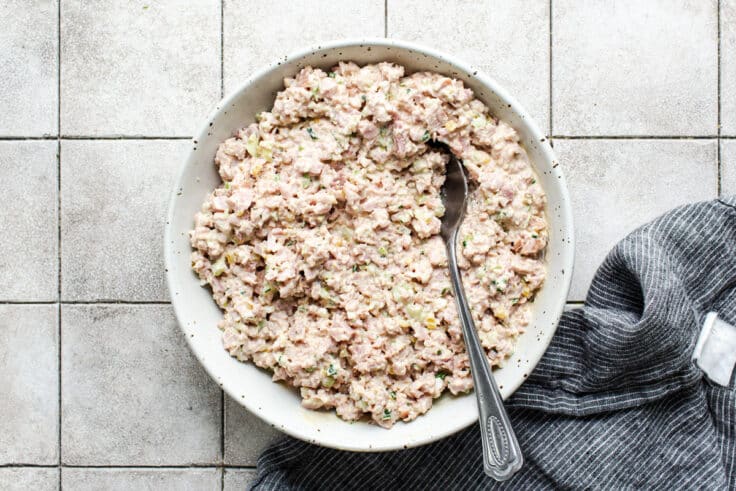 Stirring together ham salad in a mixing bowl.