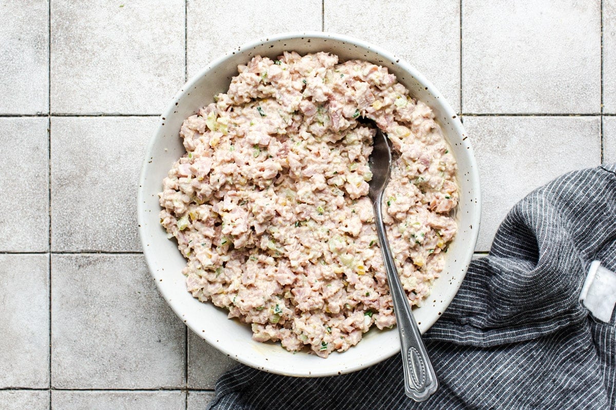 Stirring together ham salad in a mixing bowl.