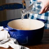 Pouring water into a Dutch oven.