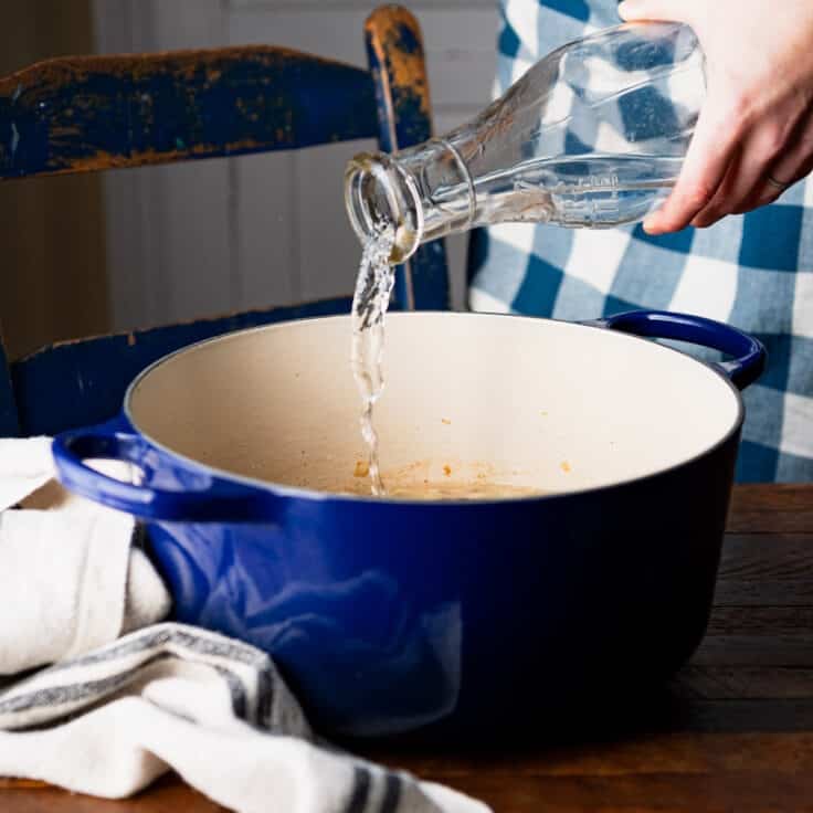 Pouring water into a Dutch oven.