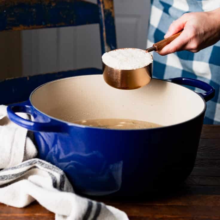 Adding rice to the Dutch oven.