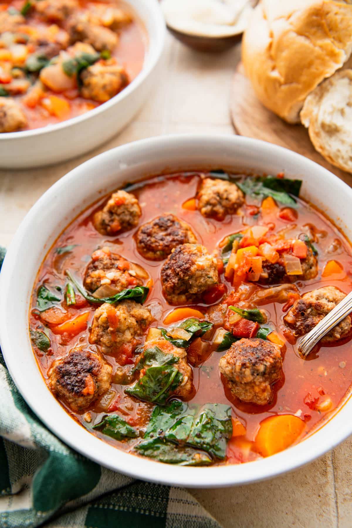 Side shot of bowls of Italian meatball soup on a table.