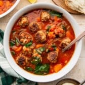 Square overhead shot of a bowl of Italian meatball soup.