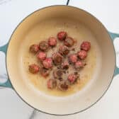Browning homemade meatballs in a Dutch oven.