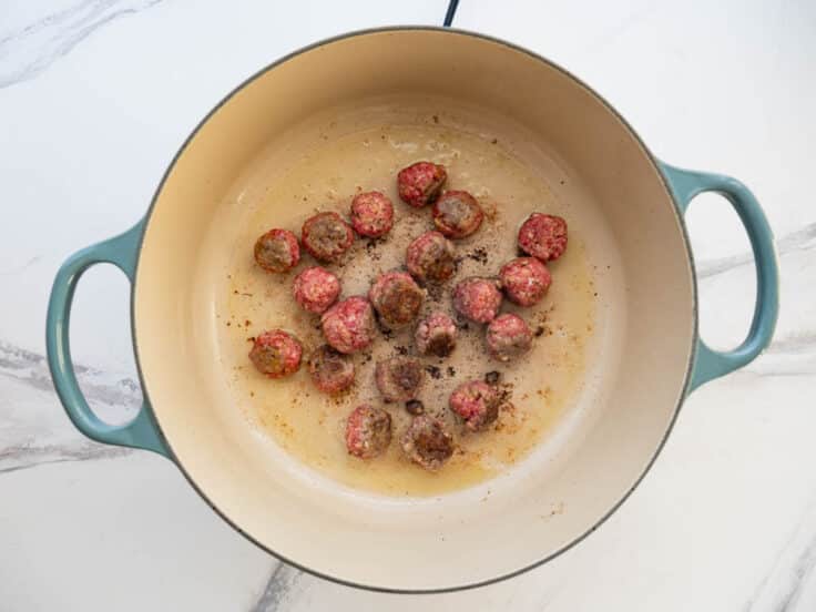Browning homemade meatballs in a Dutch oven.