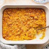 Horizontal overhead shot of old fashioned scalloped corn in a white baking dish.