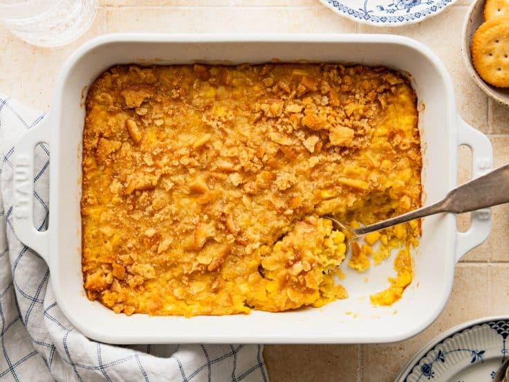 Horizontal overhead shot of old fashioned scalloped corn in a white baking dish.