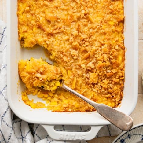 Square overhead shot of scalloped corn in a white dish.