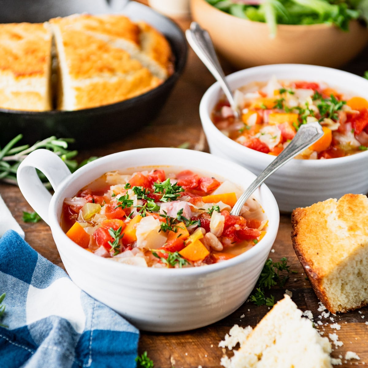 Side shot of two bowls of ham bone soup.