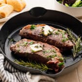 Horizontal side shot of a cast iron skillet steak recipe.
