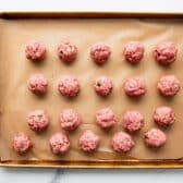 Meatballs on a baking sheet before browning.