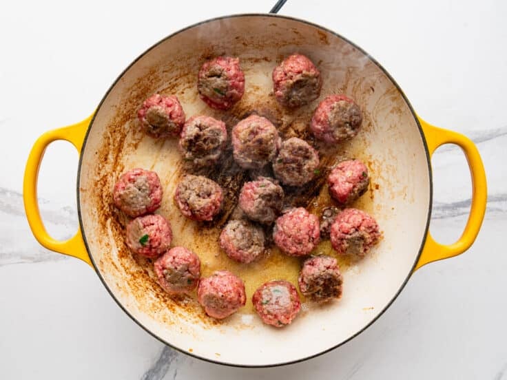 Browning meatballs in a skillet.