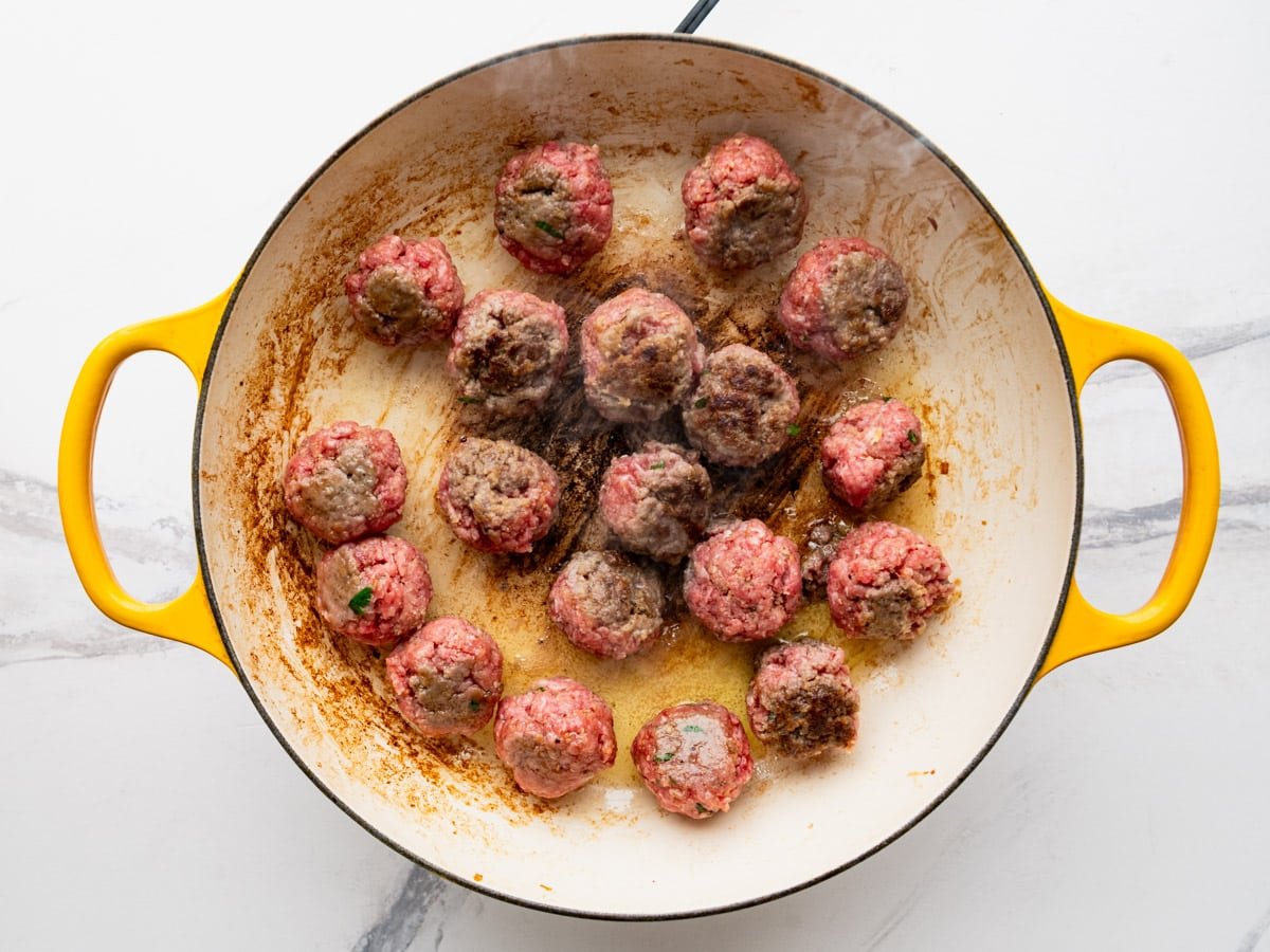 Browning meatballs in a skillet.