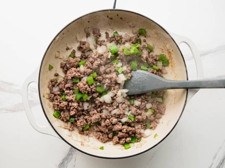 Browning ground beef with onion and green bell pepper.
