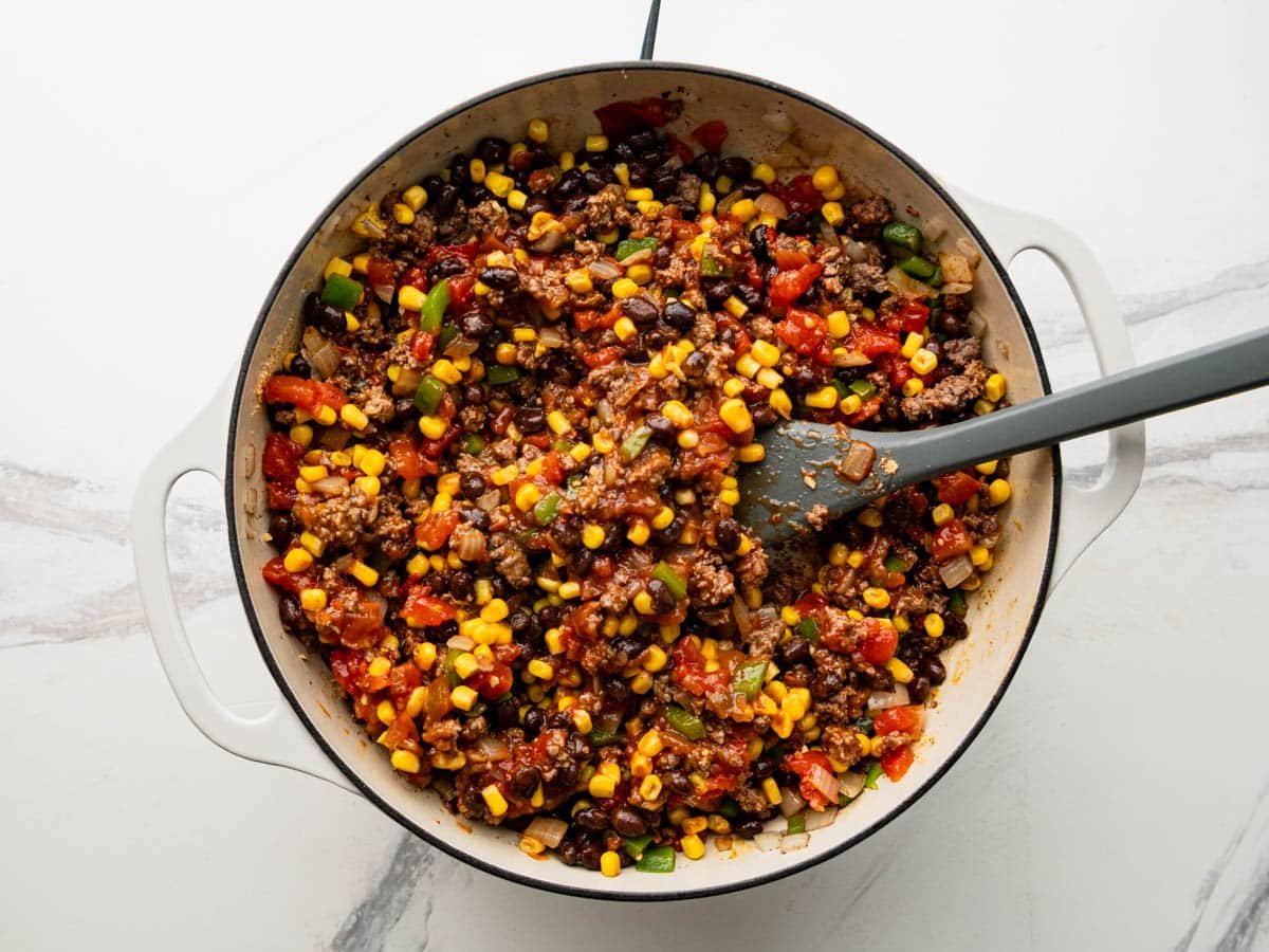 Stirring together the meat filling for a tex mex casserole.