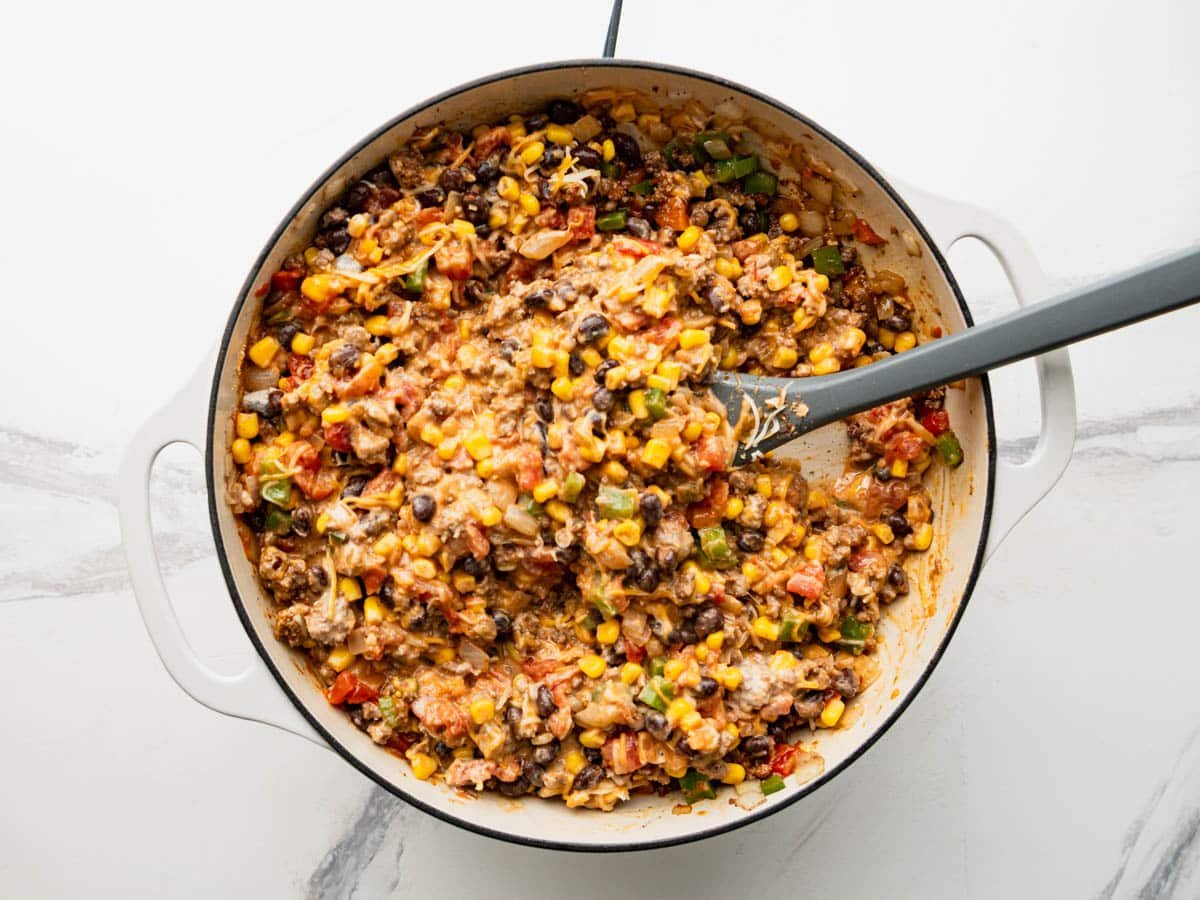 Adding sour cream and cheese to the meat filling.