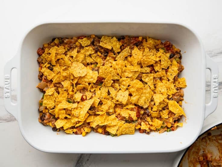 Crushed tortilla chips on top of the meat filling.