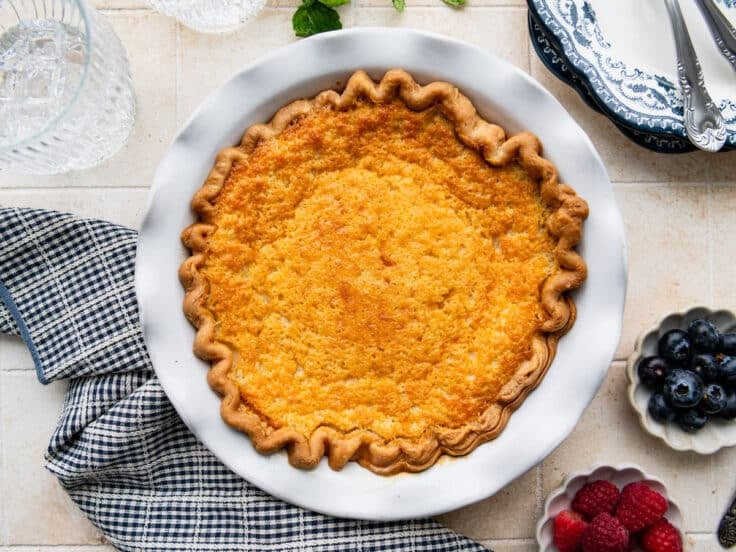 Overhead image of a baked buttermilk pie with a golden brown top after it comes out of the oven.