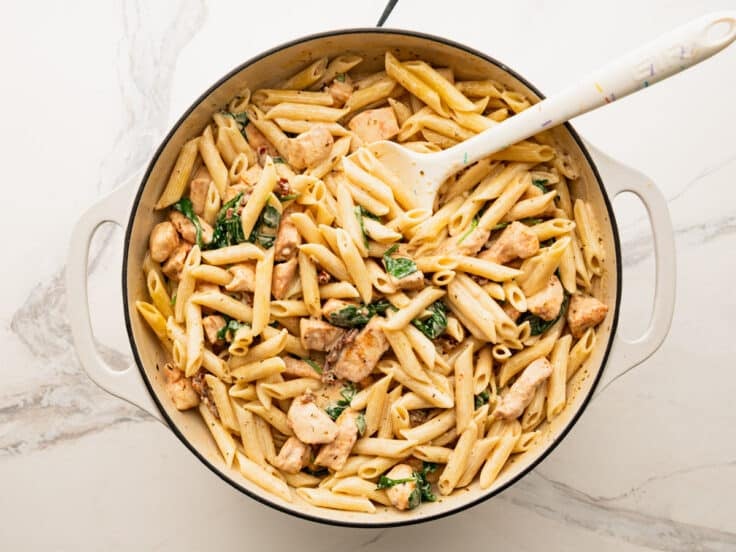 Adding the pasta and chicken back to the skillet.