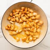 Browning the chicken breast in a skillet.