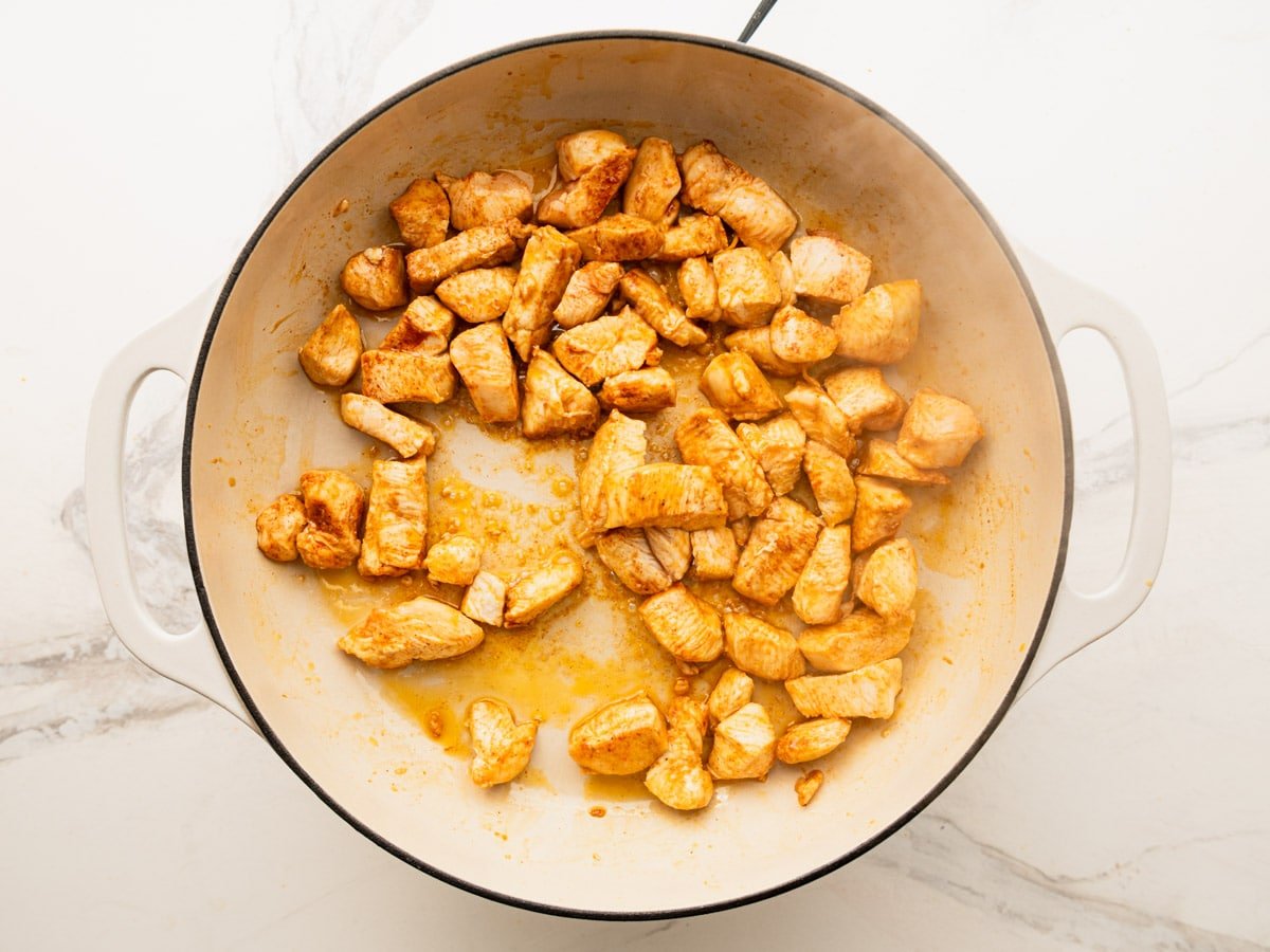 Browning the chicken breast in a skillet.