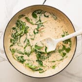 Stirring the spinach into the skillet.