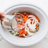 Pouring Guinness into the slow cooker.