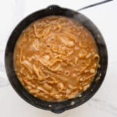 Simmering the sauce for French onion pork chops.