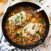 Square overhead shot of French onion pork chops in a cast iron skillet.