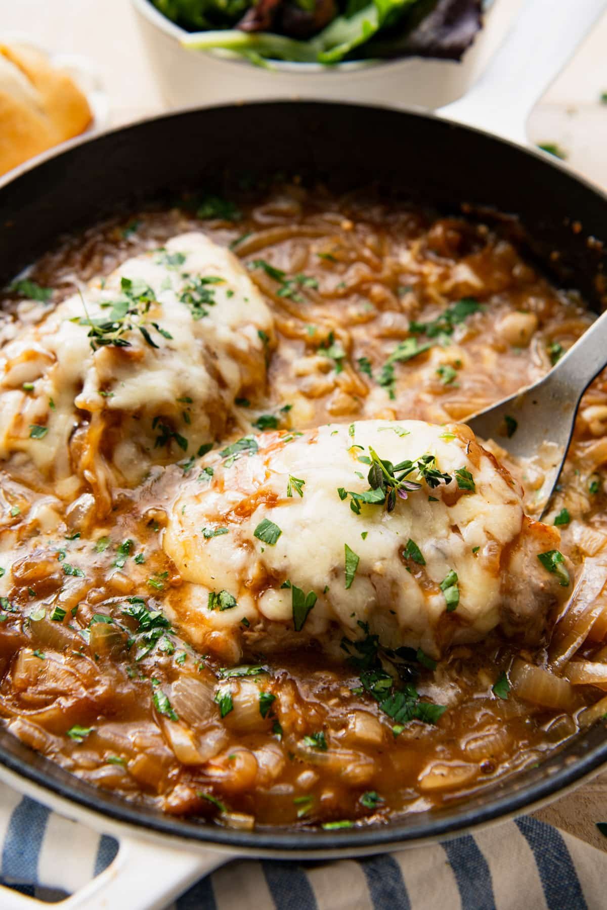 Close up shot of french onion pork chops in a skillet.