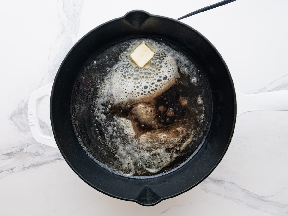 Melting the butter in a cast iron skillet.