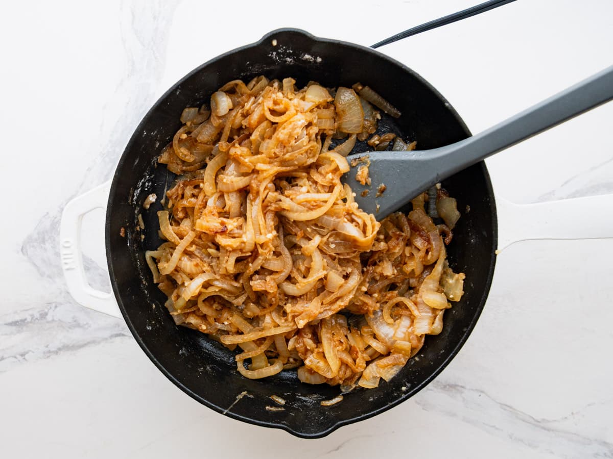 Adding garlic and seasoning to the caramelized onions.