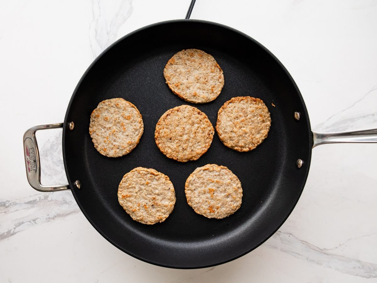 Browning sausage patties in a skillet.