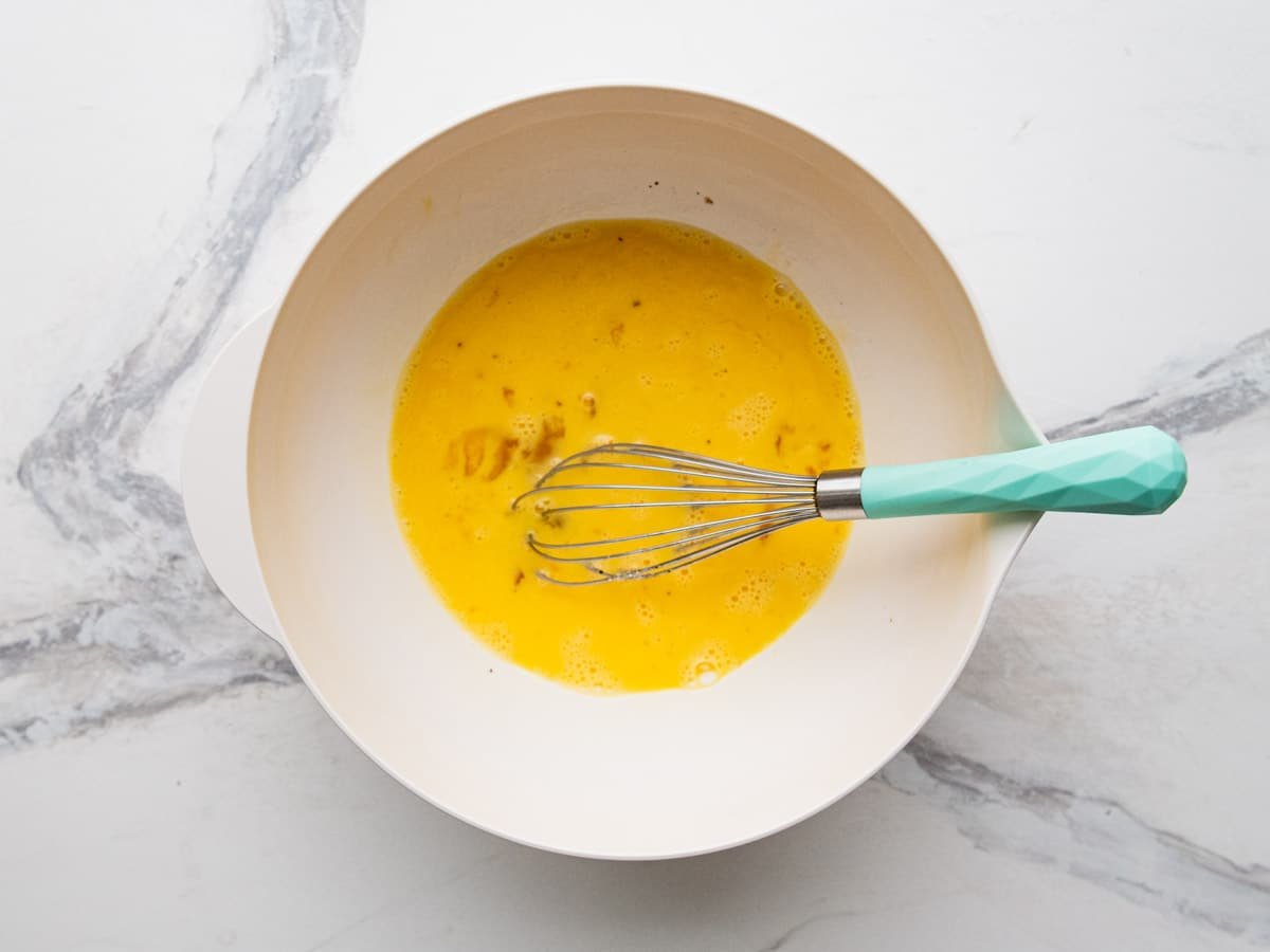 Whisking together the ingredients for scrambled eggs.