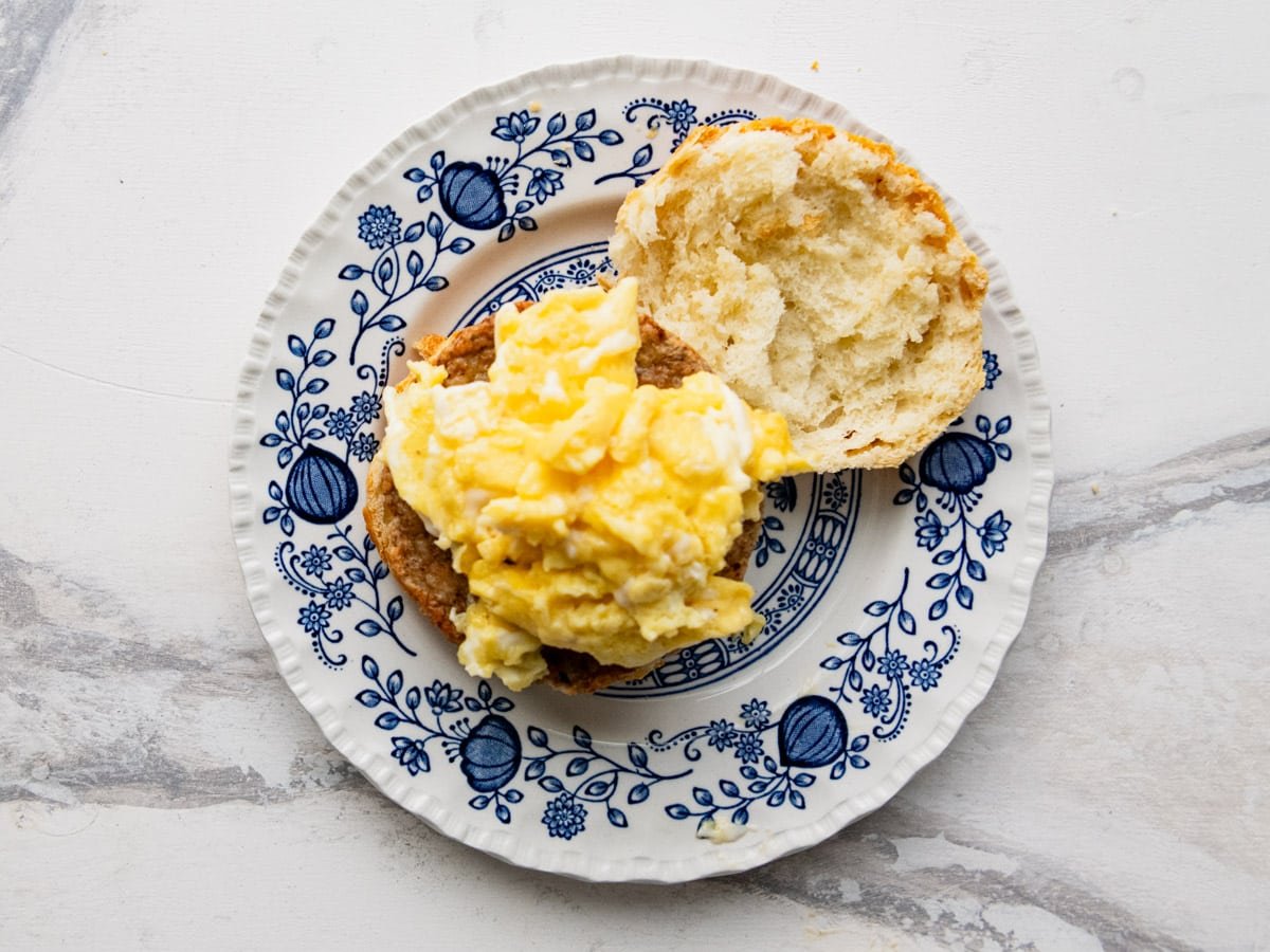 Adding the eggs to the sandwich.