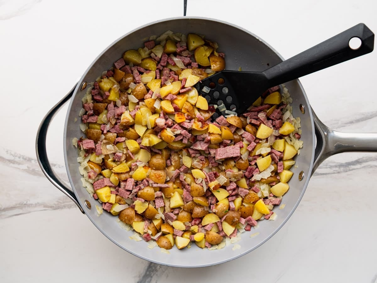 Pressing corned beef hash to make it crispy.
