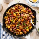 Square overhead image of a cast iron skillet full of homemade corned beef hash.