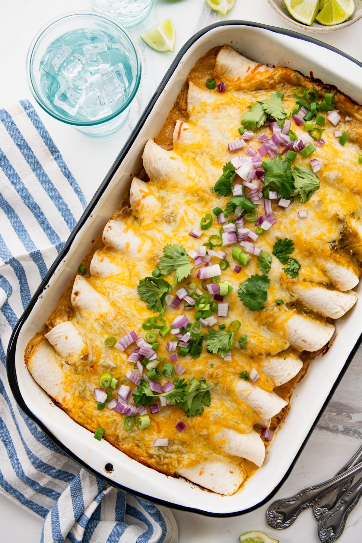 Overhead image of a pan of creamy chicken enchiladas.